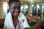 Portrait of happy woman holding water bottle after workout